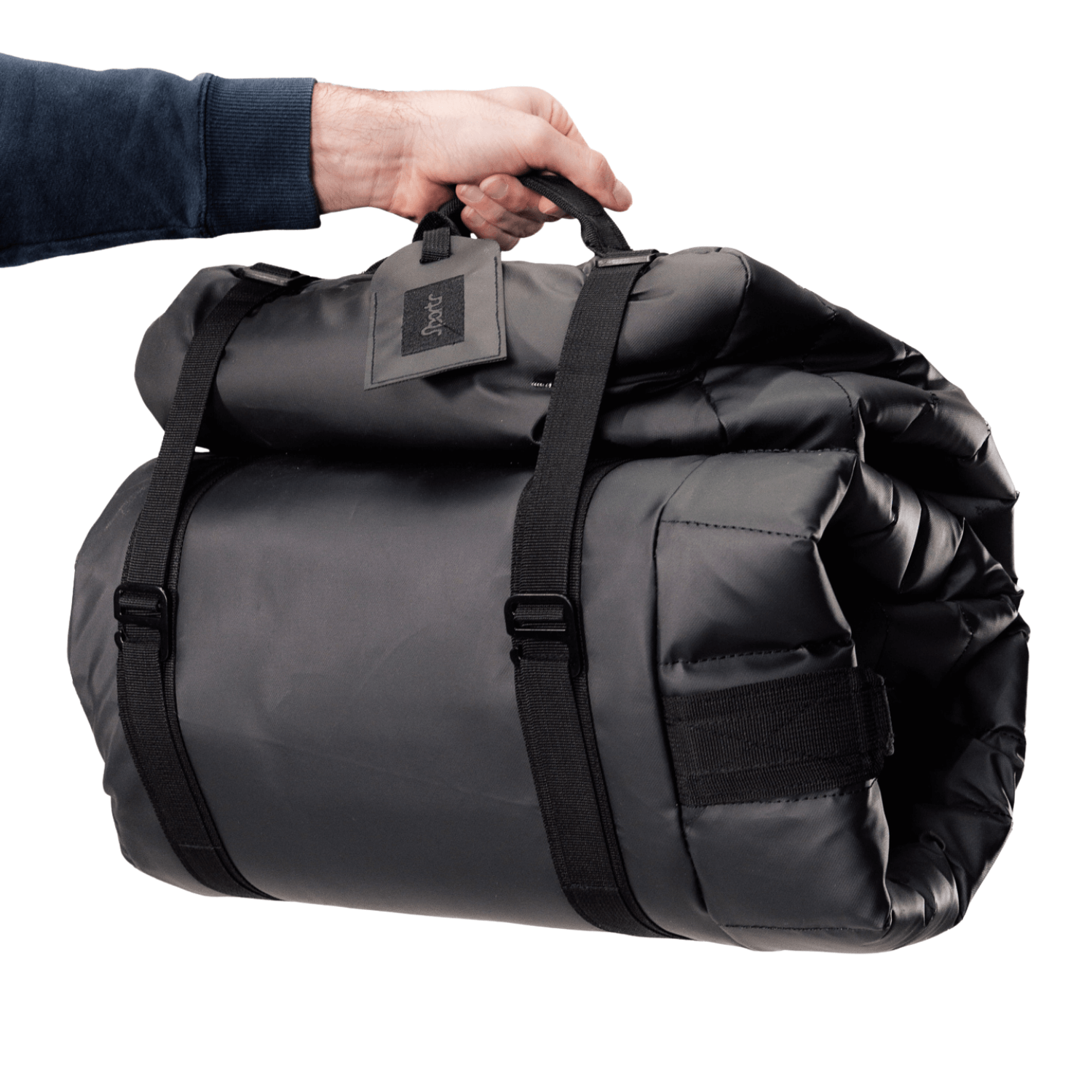 Black rolled up Sportr Golf Travel Bag with a visible brand tag held by a hand on a white background