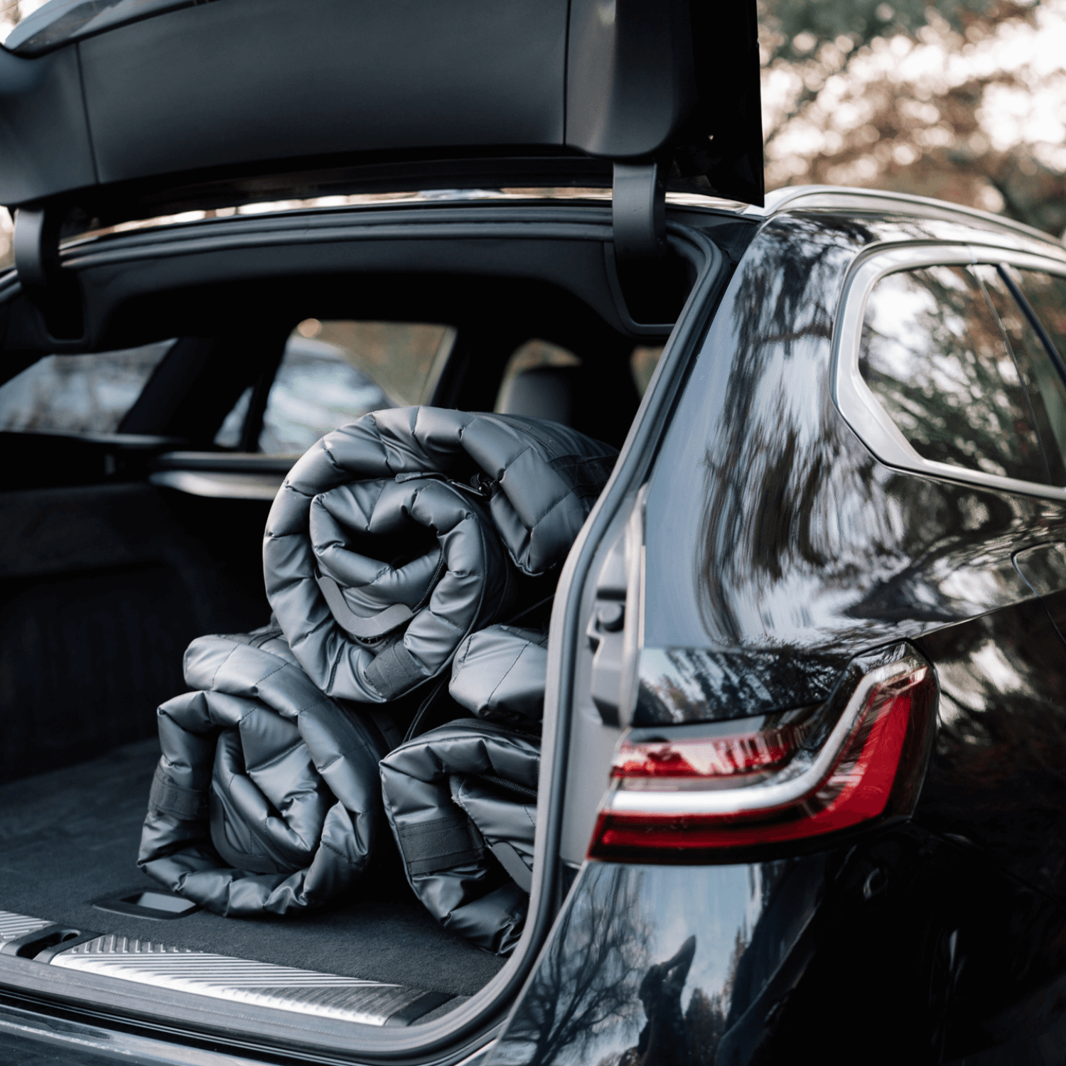 Car trunk with rolled-up Sportr Golf Travel Bags inside