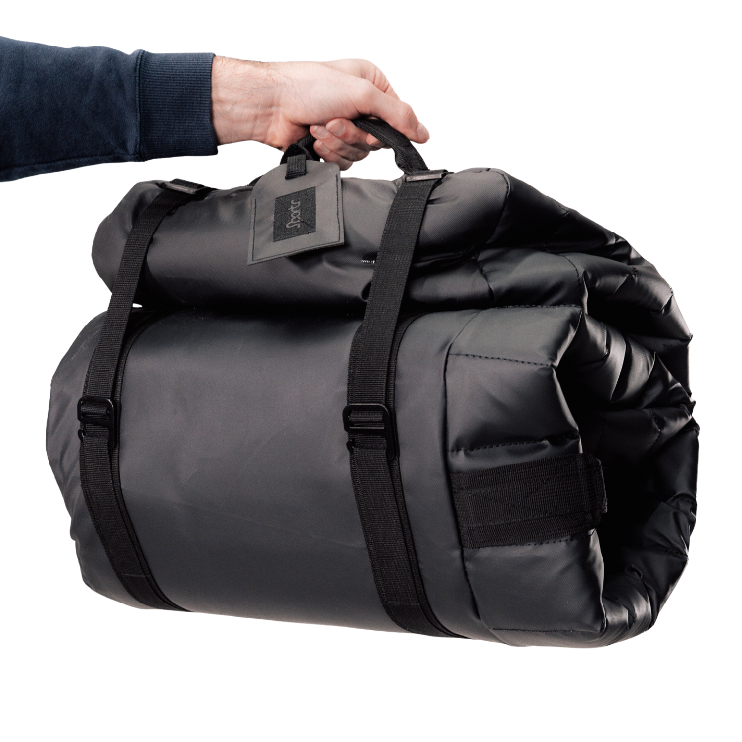 Black rolled up Sportr Golf Travel Bag with a visible brand tag held by a hand on a white background